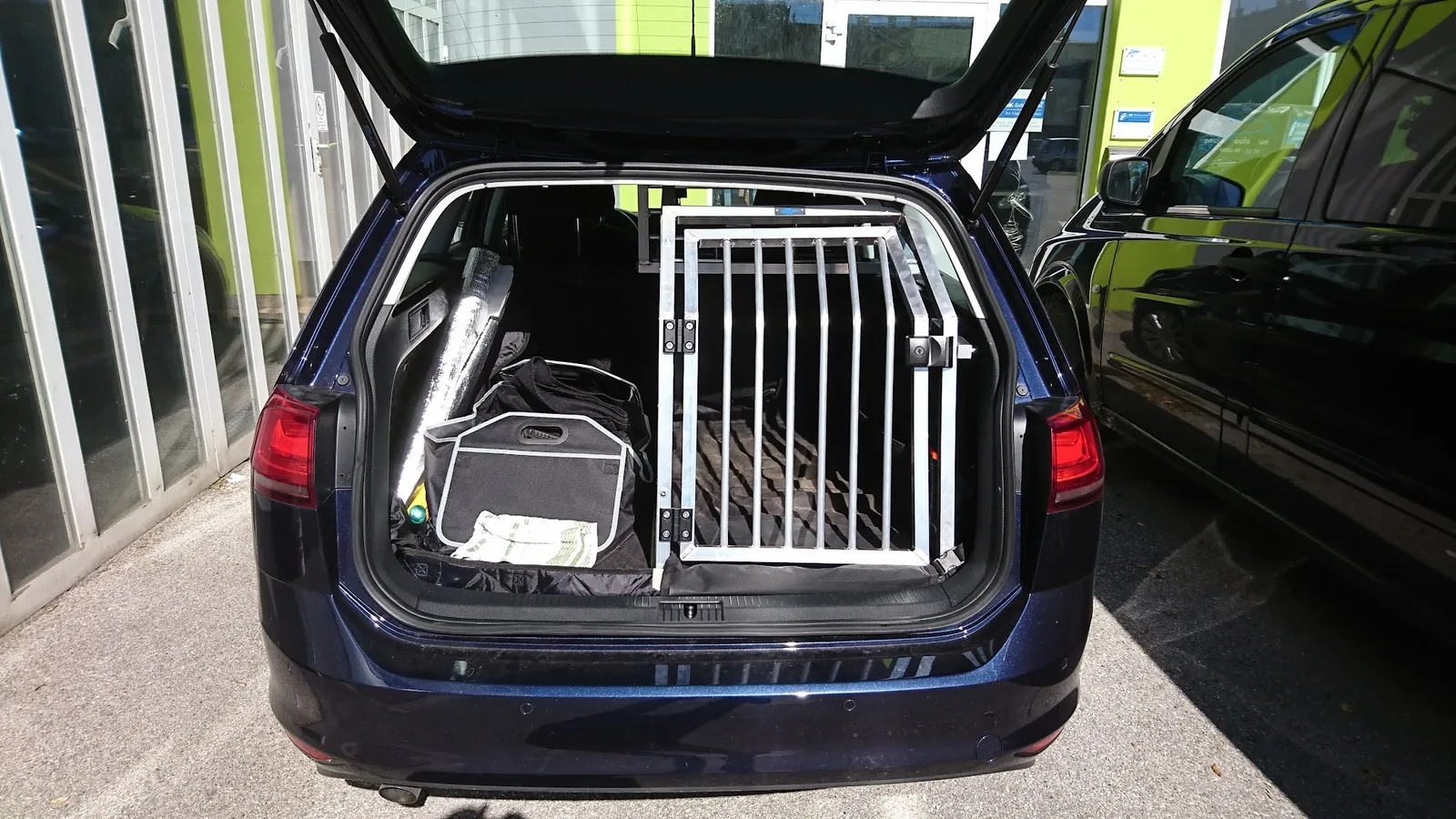Einzelne Hundebox im Kombi vor dem Betriebsgebäude